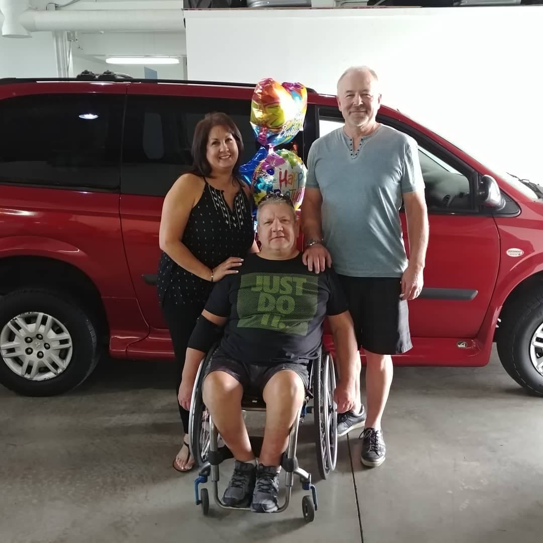A family celebrating a new accessible van at the Sidewinder showroom